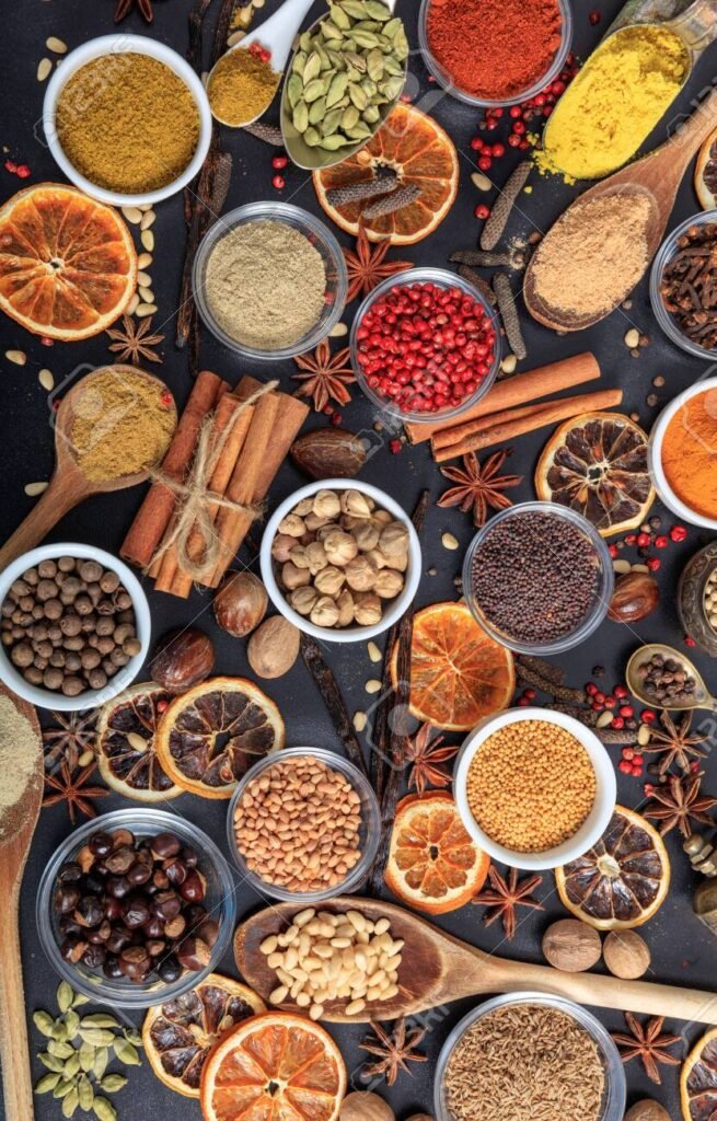 spices and herbs flat lay, black background, top view.